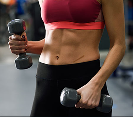 mujer haciendo pessas en gimnasio con cicatriz en abdomen