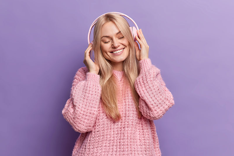 mujer con sonrisa hermosa escuchando musica